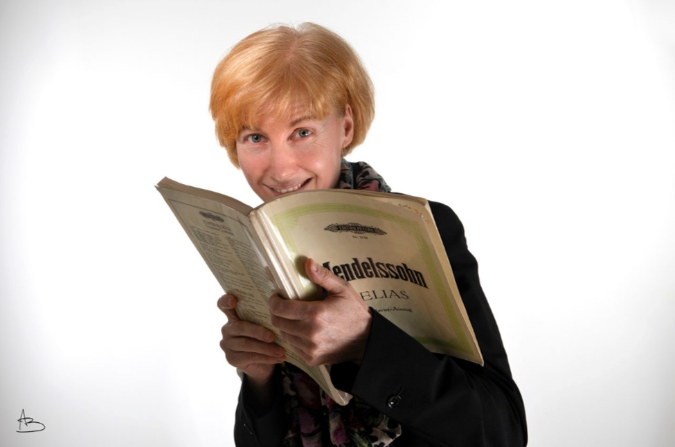 Gabi Rohe lächelnd mit Notenbuch